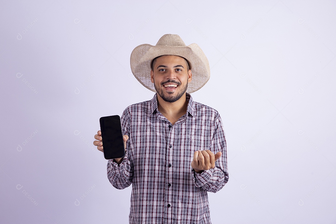 Homem jovem barbudo usando roupas de São João segurando celular smartphone