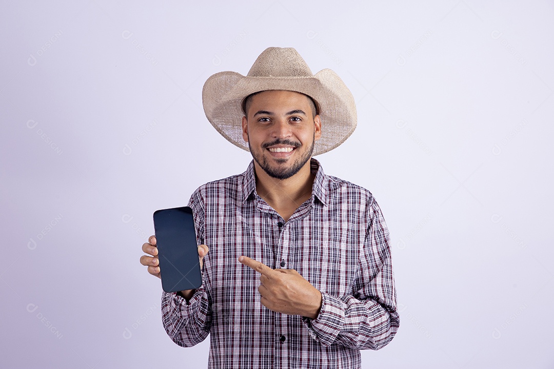 Homem jovem barbudo usando roupas de São João segurando celular smartphone