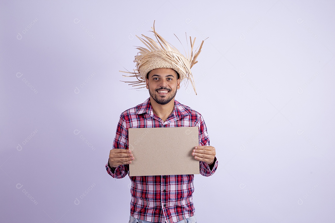 Homem jovem barbudo fantasiado celebrando festas juninas segurando quadro