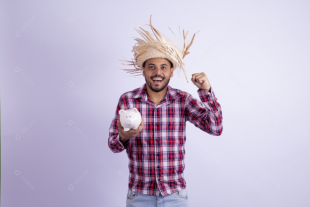 Homem jovem barbudo fantasiado celebrando festas juninas segurando cofrinho