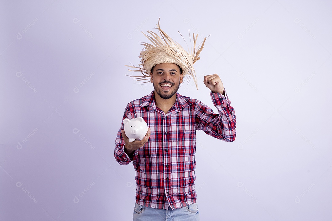 Homem jovem barbudo fantasiado celebrando festas juninas segurando cofrinho