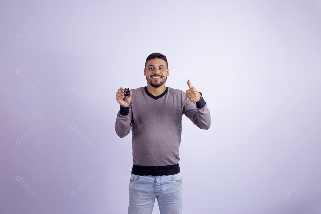Homem jovem garoto barbudo segurando chave de carro sobre fundo isolado branco