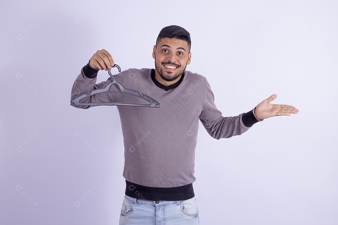 Homem jovem barbudo segurando cabide sobre fundo isolado