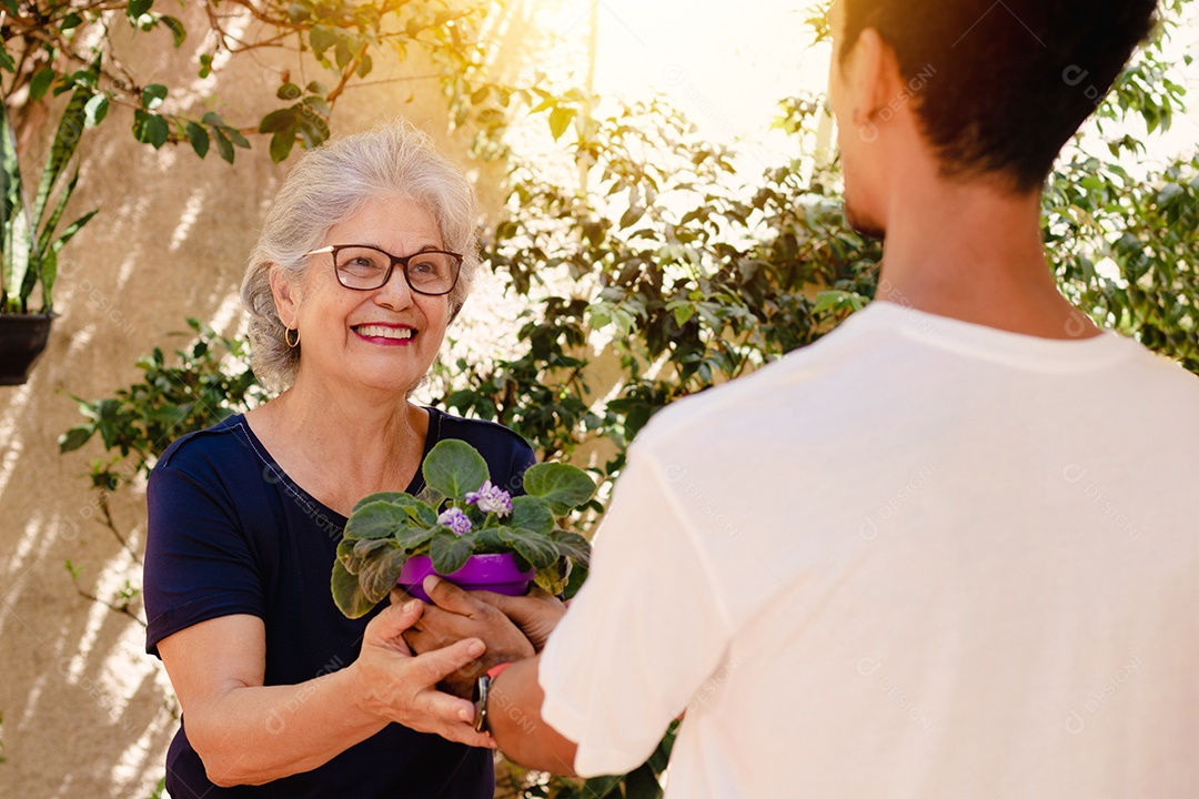 Mãe caucasiana e seu filho negro no jardim da casa. Família inter-racial feliz..