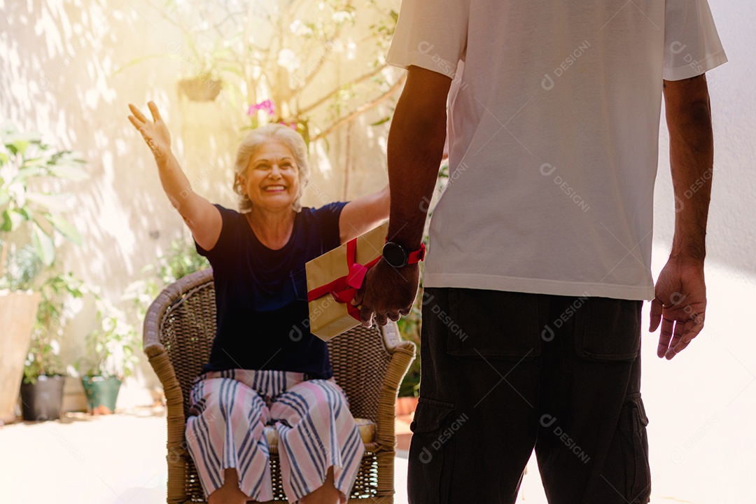 Mãe caucasiana e seu filho negro no jardim da casa. Família inter-racial feliz.