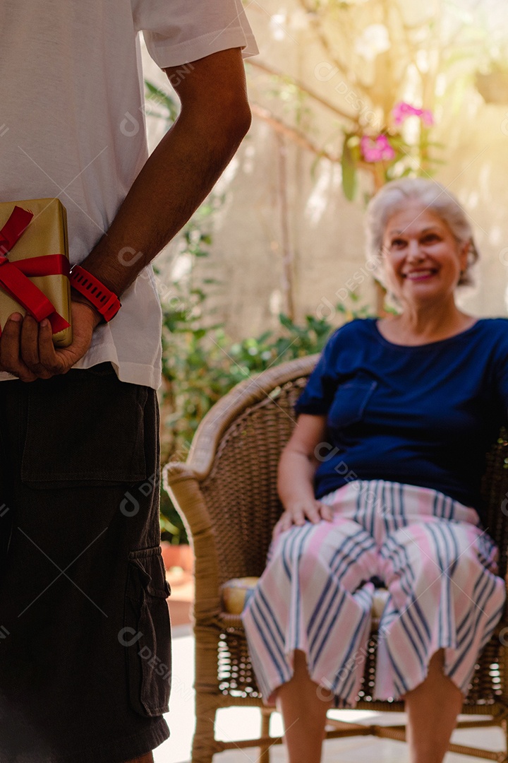 Mãe caucasiana e seu filho negro no jardim da casa. Família inter-racial feliz.