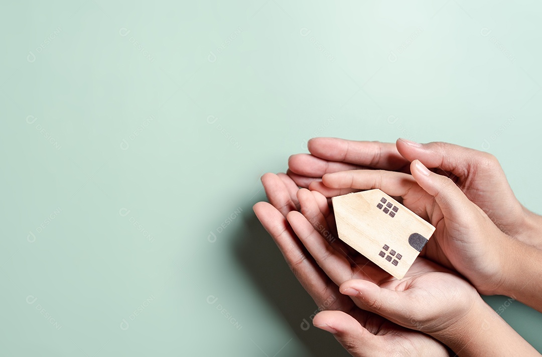 Mãos segurando uma casa de madeira, casa de família