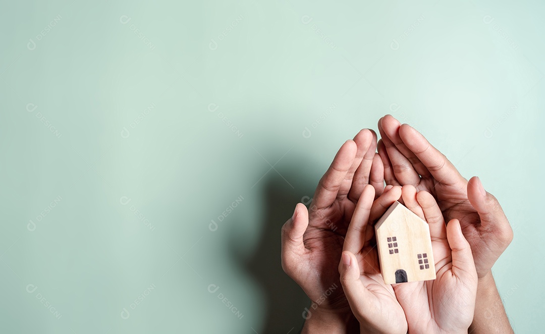 Mãos segurando uma casa de madeira, casa de família
