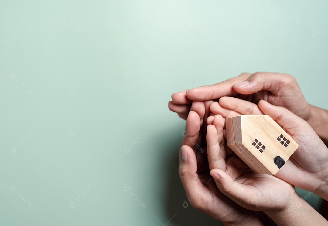 Mãos segurando uma casa de madeira, casa de família