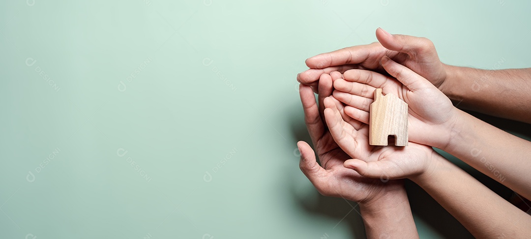 Mãos segurando uma casa de madeira, casa de família