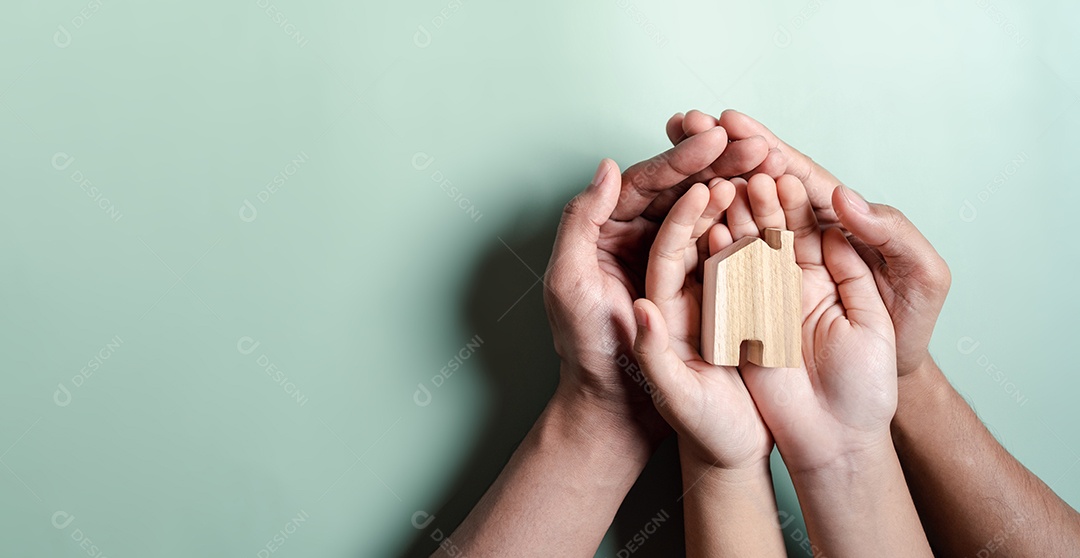 Mãos segurando uma casa de madeira, casa de família