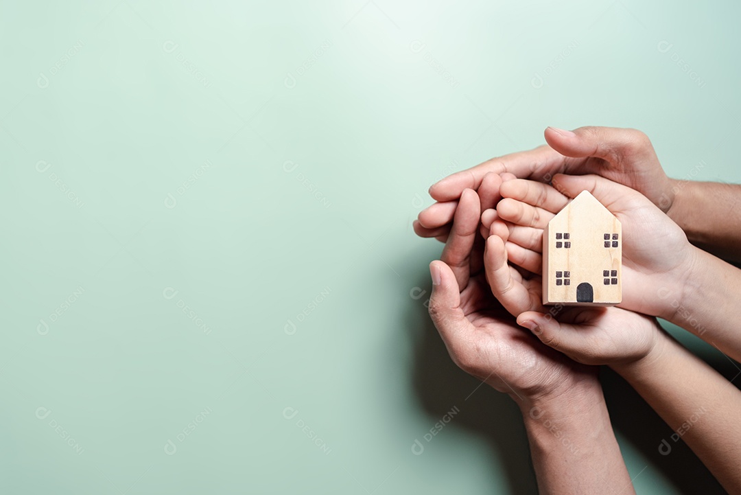 Mãos segurando uma casa de madeira, casa de família