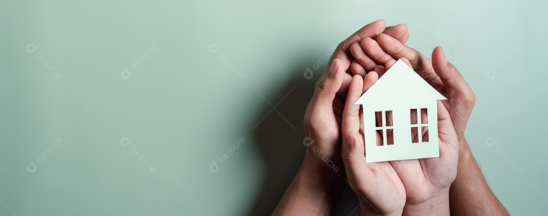 Mãos segurando uma casa de madeira, casa de família