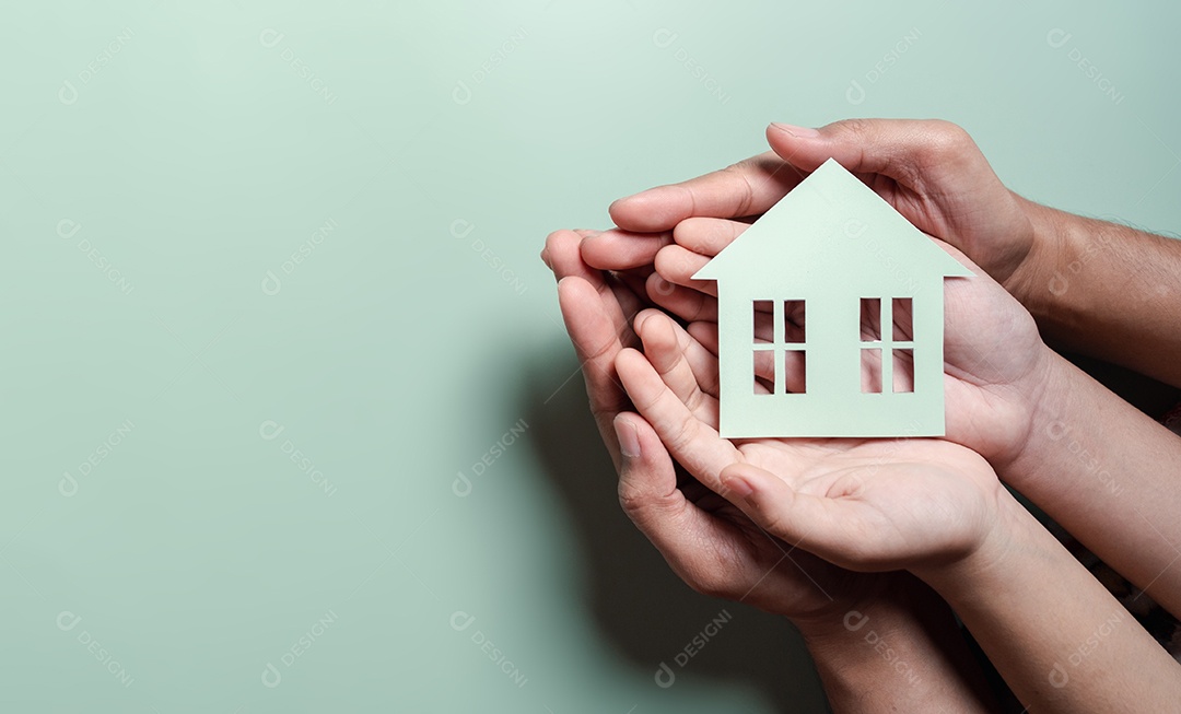 Mãos segurando uma casa de madeira, casa de família