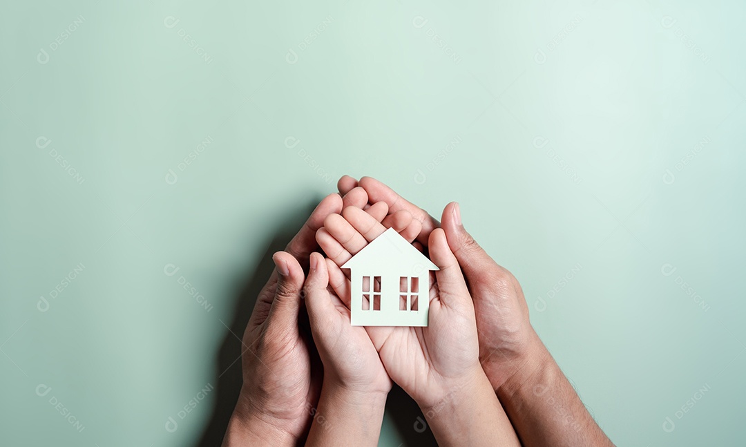 Mãos segurando uma casa de madeira, casa de família