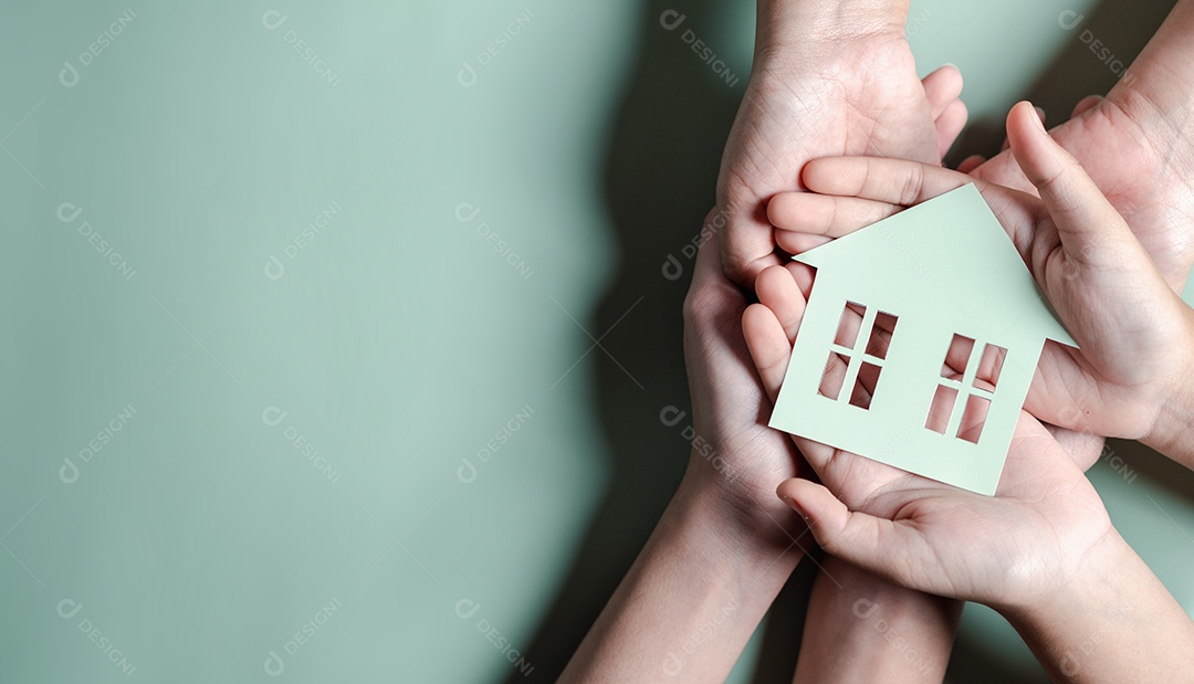 Mãos segurando uma casa de madeira, casa de família