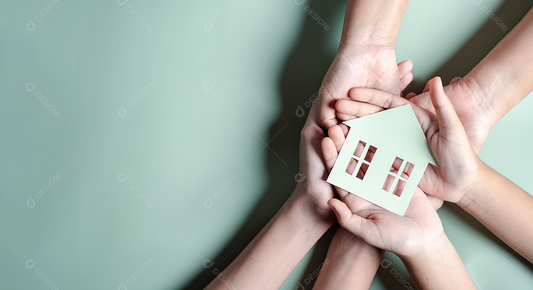 Mãos segurando uma casa de madeira, casa de família