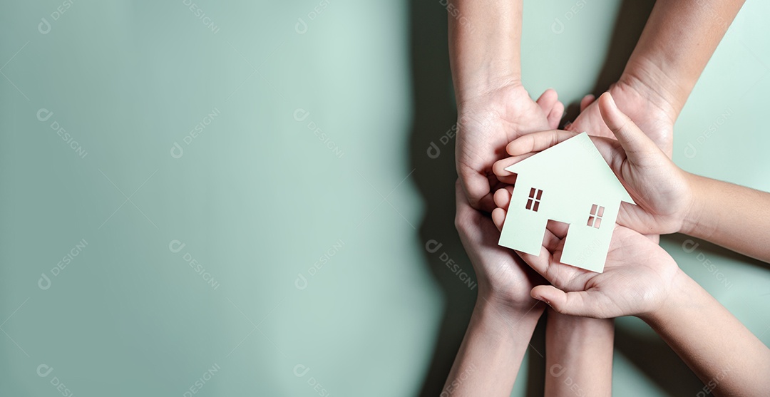 Mãos segurando uma casa de madeira, casa de família