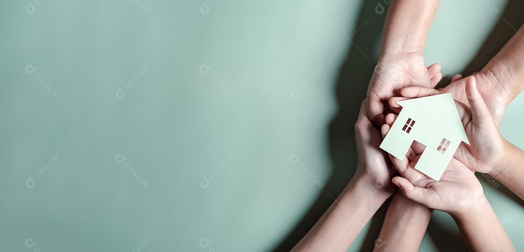 Mãos segurando uma casa de madeira, casa de família