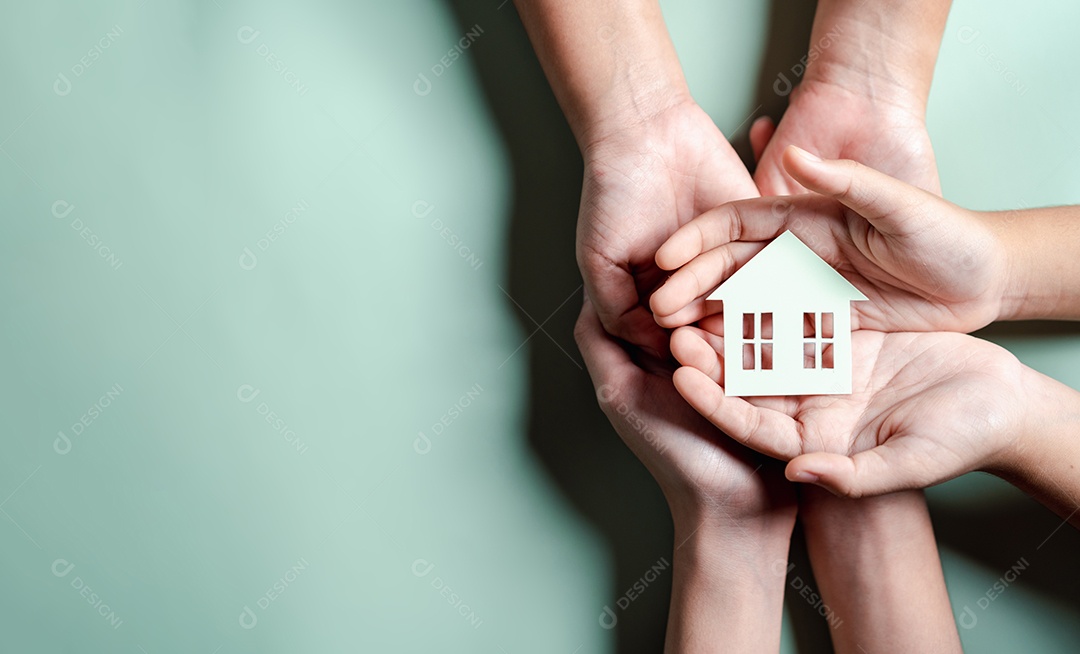 Mãos segurando uma casa de madeira, casa de família