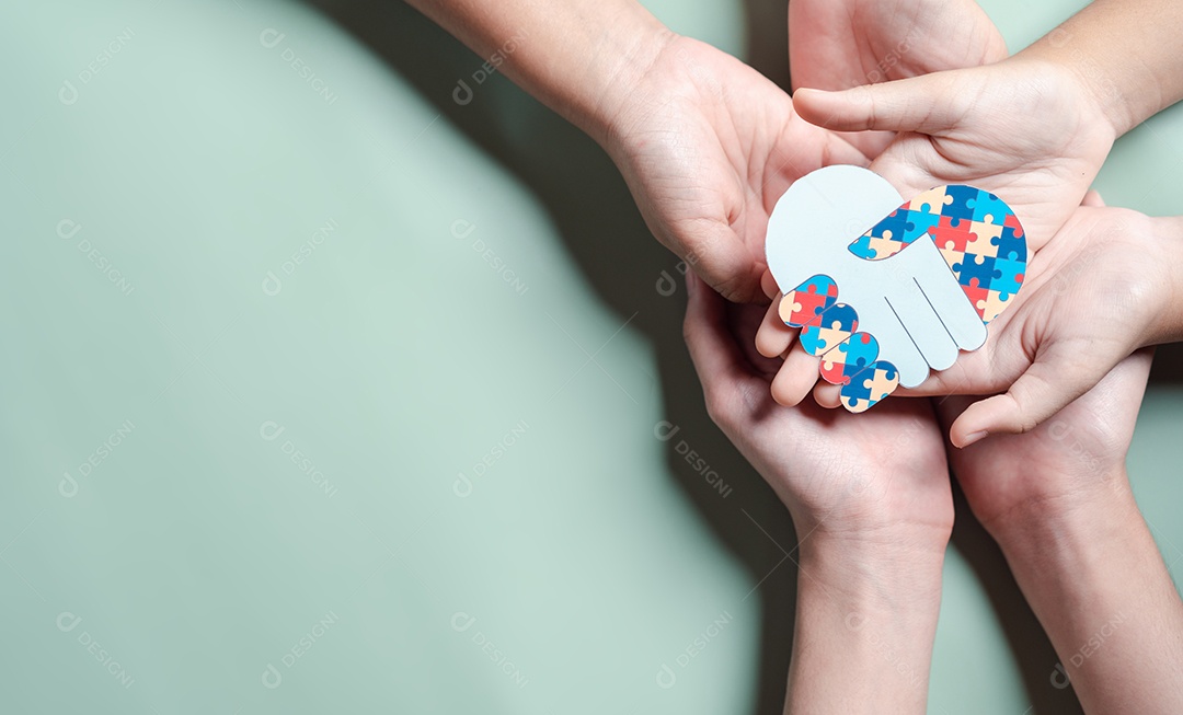 Pai, mãe, crianças segurando quebra-cabeças de coração apoio familiar ao transtorno do espectro autista.