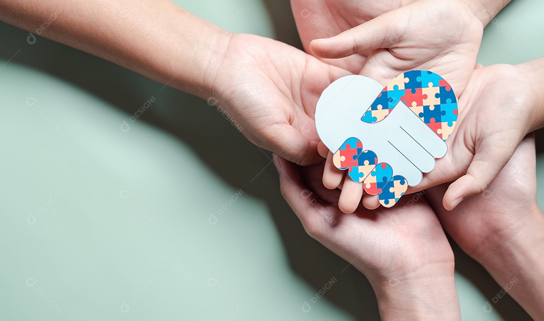 Pai, mãe, crianças segurando quebra-cabeças de coração apoio familiar ao transtorno do espectro autista.