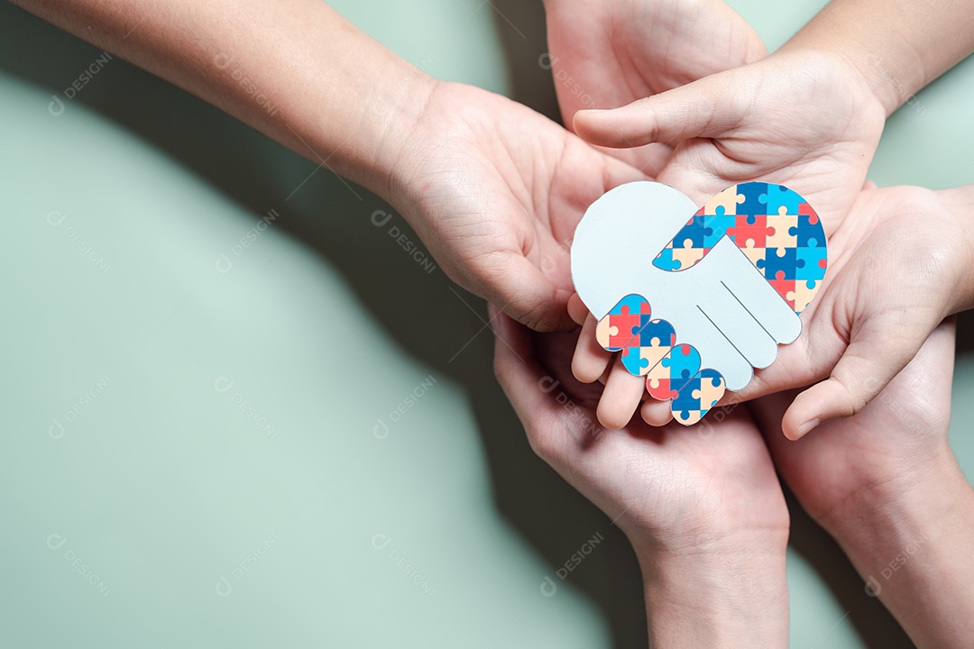 Pai, mãe, crianças segurando quebra-cabeças de coração apoio familiar ao transtorno do espectro autista.