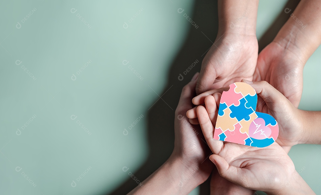 Pai, mãe, crianças segurando quebra-cabeças de coração apoio familiar ao transtorno do espectro autista.