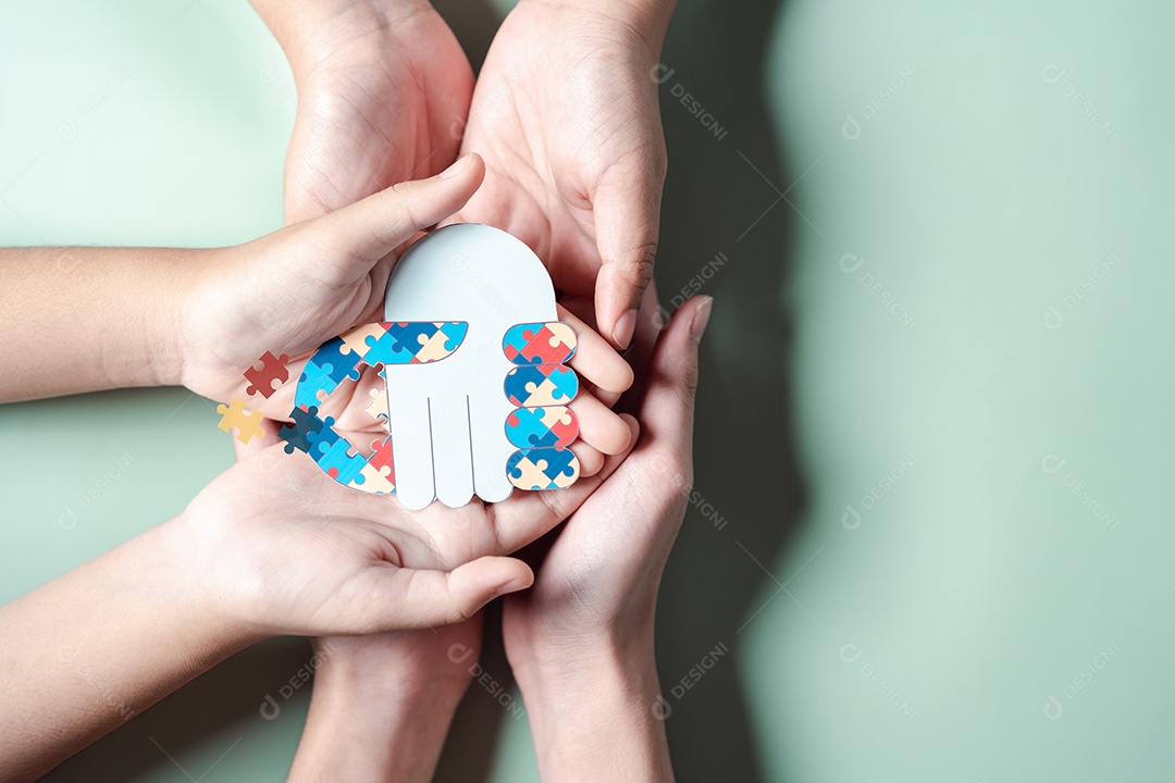 Pai, mãe, crianças segurando quebra-cabeças de coração apoio familiar ao transtorno do espectro autista.