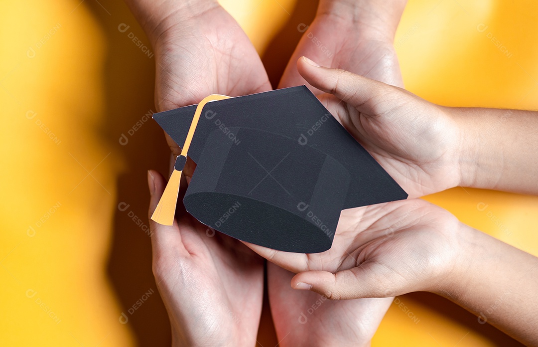 Mãos segurando chapéu de pós-graduação com aprendizagem educar, estudar conhecimento para ideia