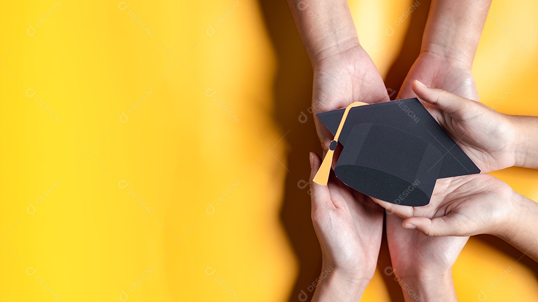 Mãos segurando chapéu de pós-graduação com aprendizagem educar, estudar conhecimento para ideia