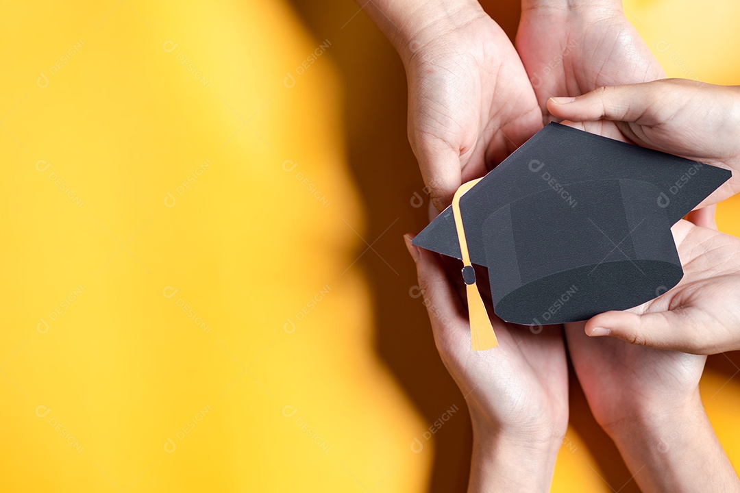 Mãos segurando chapéu de pós-graduação com aprendizagem educar, estudar conhecimento para ideia