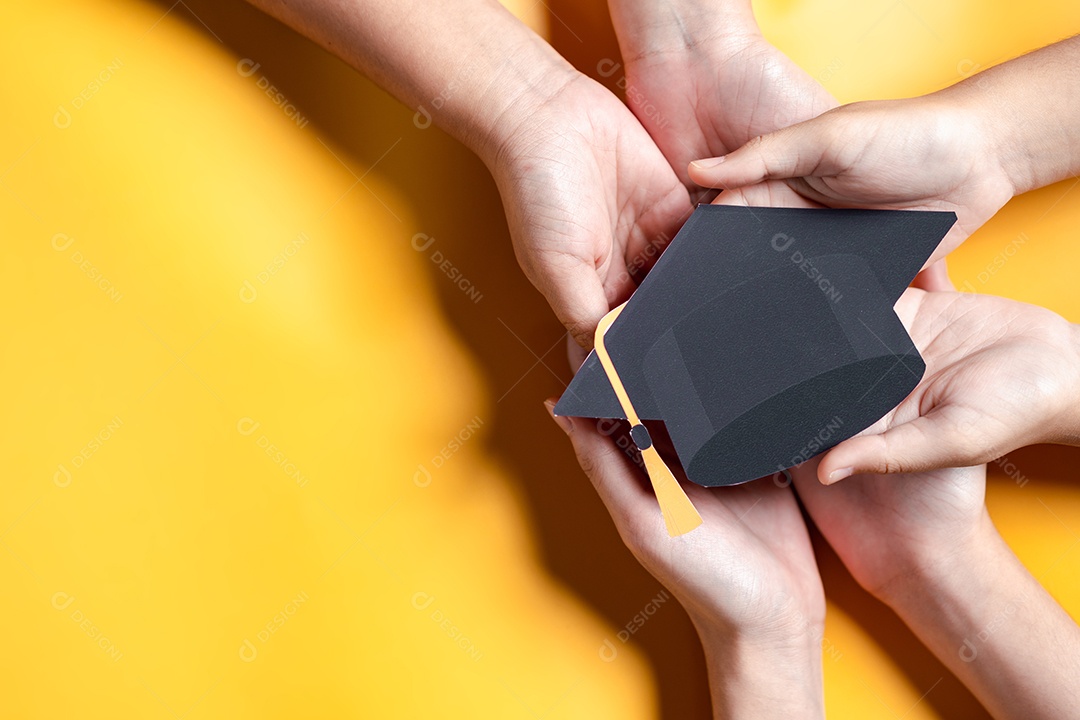 Mãos segurando chapéu de pós-graduação com aprendizagem educar, estudar conhecimento para ideia