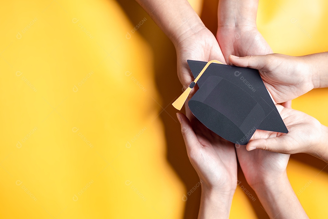 Mãos segurando chapéu de pós-graduação com aprendizagem educar, estudar conhecimento para ideia