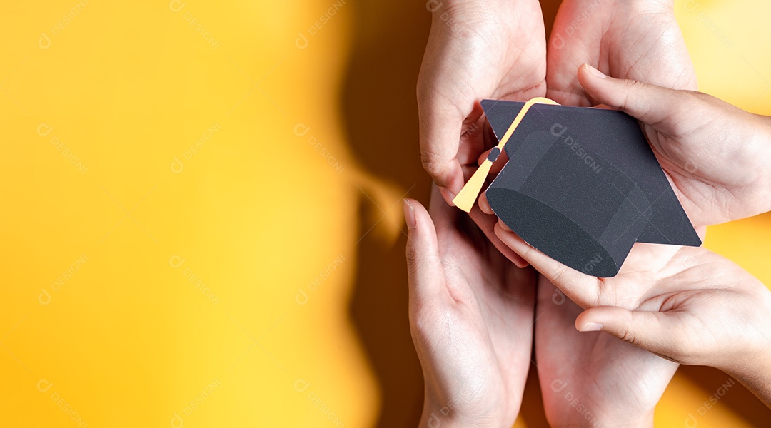 Mãos segurando chapéu de pós-graduação com aprendizagem educar, estudar conhecimento para ideia
