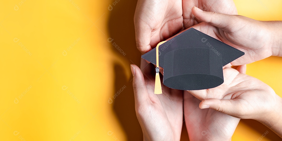 Mãos segurando chapéu de pós-graduação com aprendizagem educar, estudar conhecimento para ideia