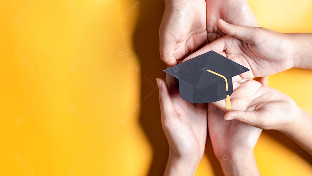 Mãos segurando chapéu de pós-graduação com aprendizagem educar, estudar conhecimento para ideia