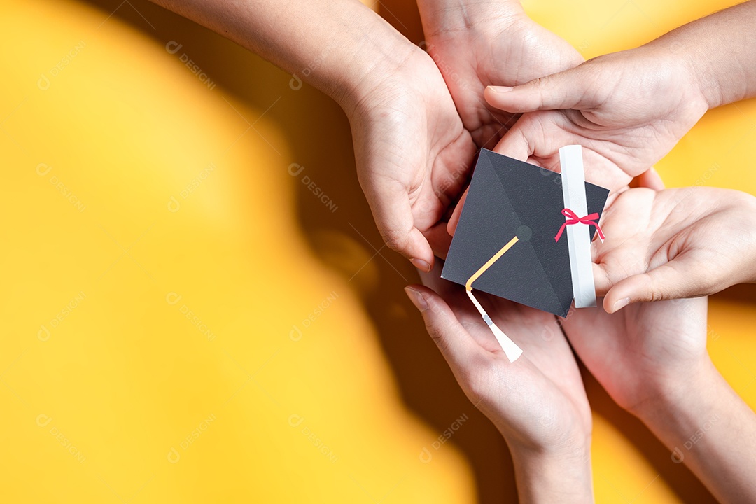 Mãos segurando chapéu de pós-graduação com aprendizagem educar, estudar conhecimento para ideia