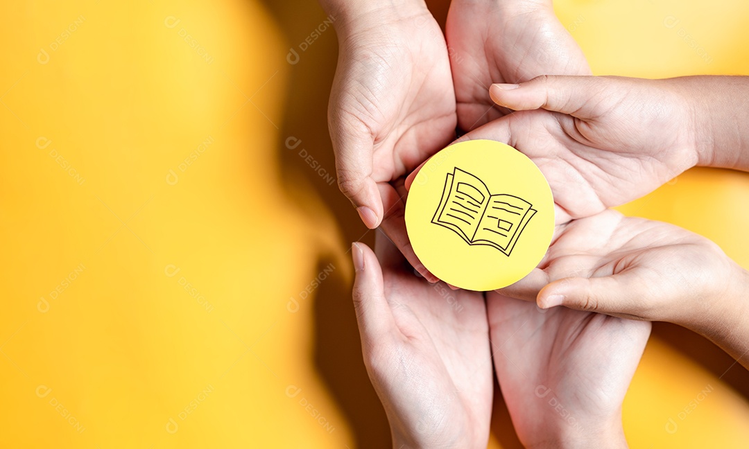 Mãos segurando um livro didático para aprender a educar, estudar