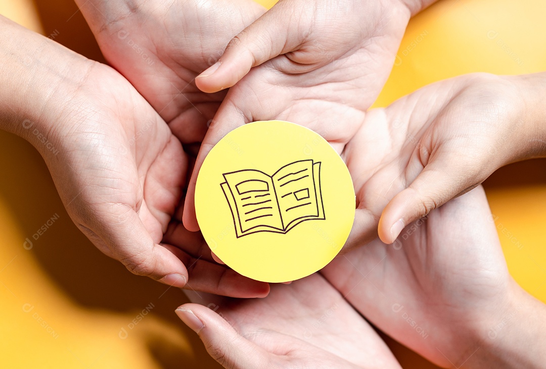 Mãos segurando um livro didático para aprender a educar, estudar