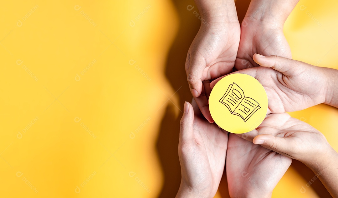 Mãos segurando um livro didático para aprender a educar