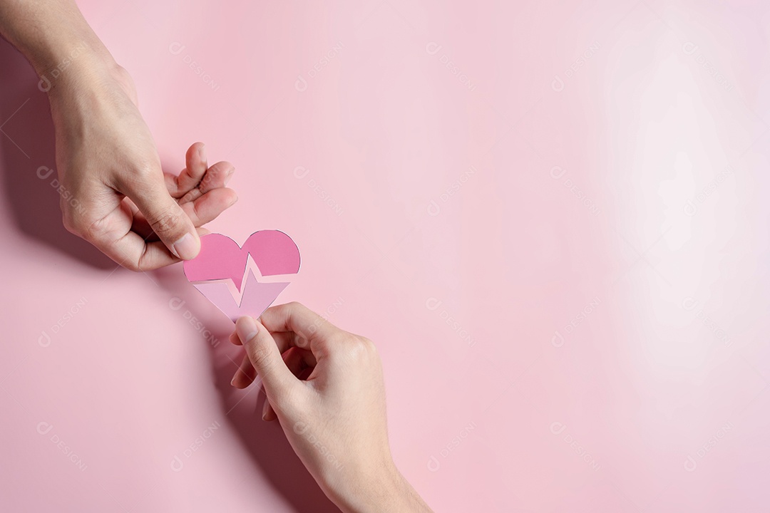 Mãos segurando o conceito de doação de coração rosa, cuidados de saúde