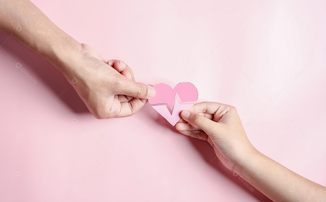 Mãos segurando o conceito de doação de coração rosa, cuidados de saúde