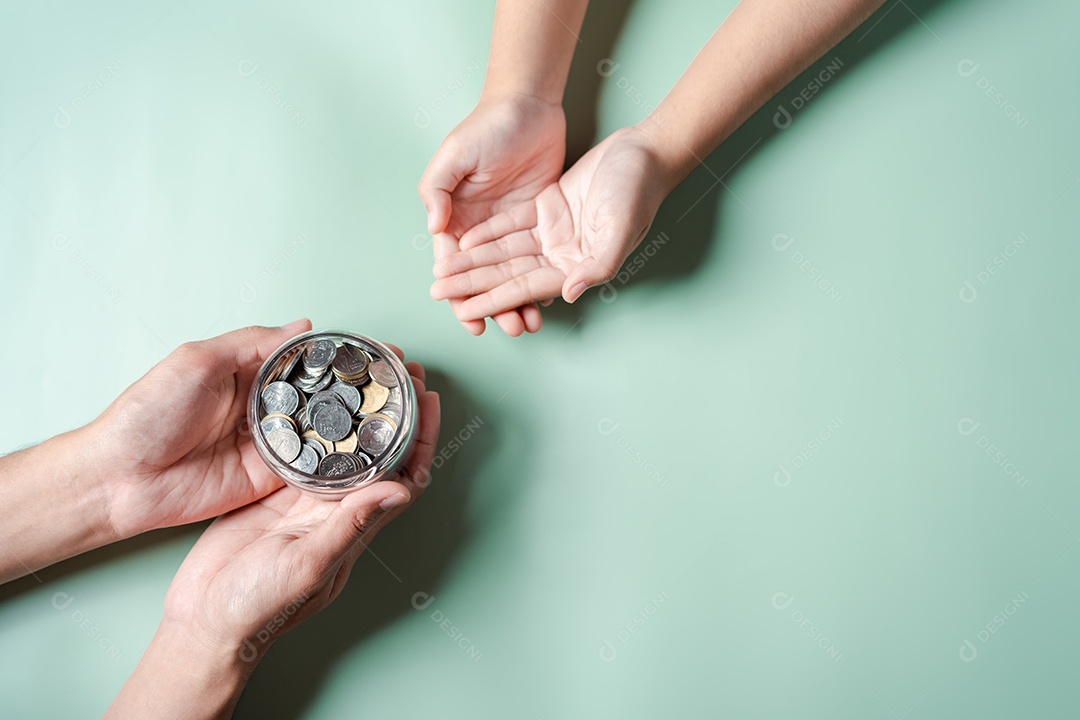 Mãos de adulto e criança segurando pote de dinheiro, doação, poupança