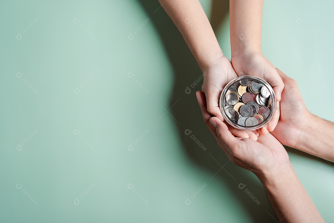 Mãos de adulto e criança segurando pote de dinheiro, doação, poupança