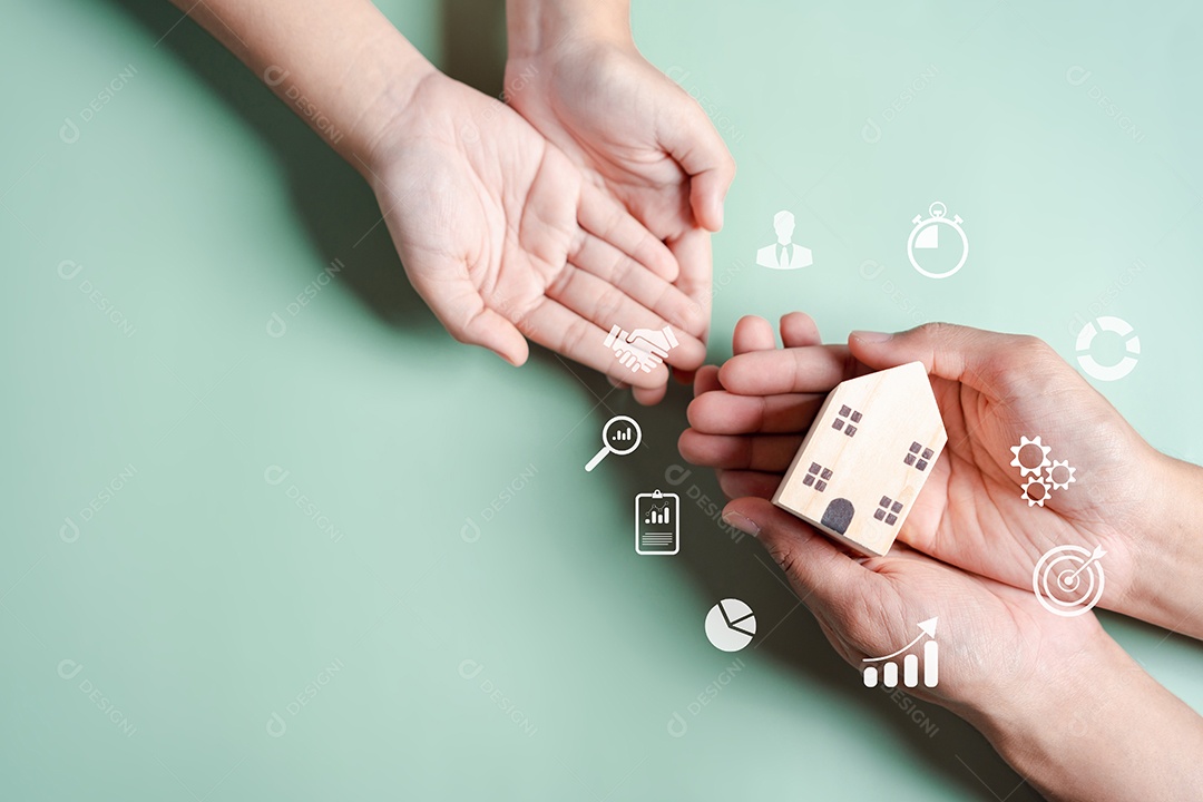 Mãos segurando uma casa de madeira