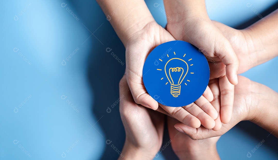 Mãos segurando uma lâmpada com liderança de desenvolvimento de planejamento de alvo de negócios