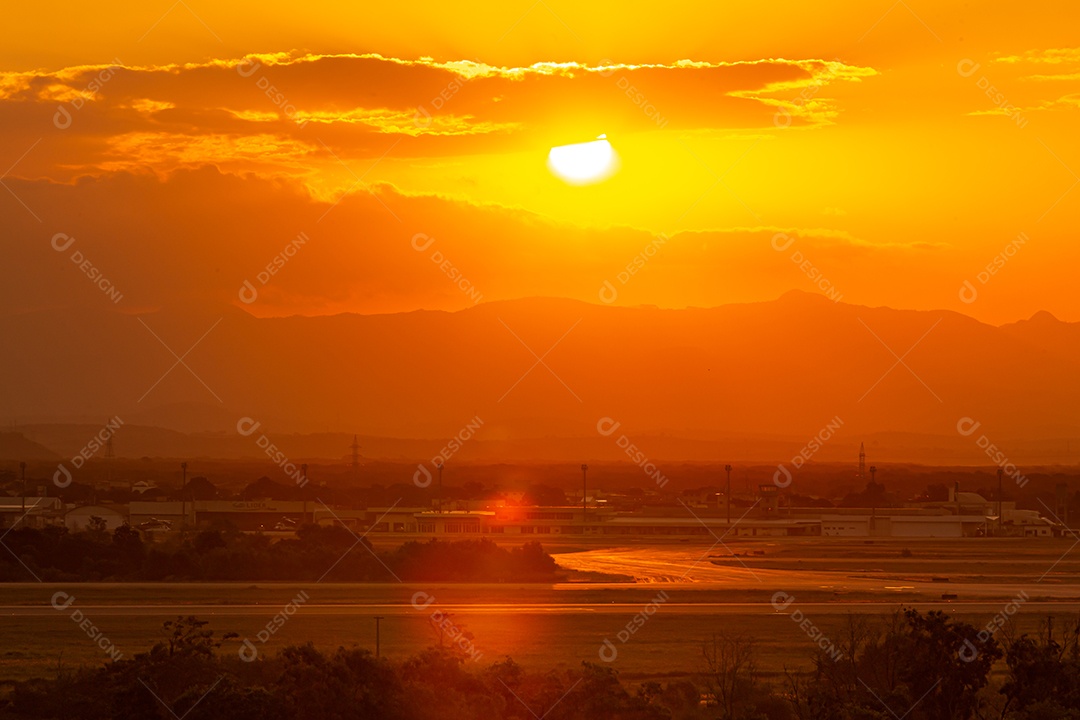 Lindo pôr do sol, com o aeroporto de Vitória em primeiro plano e uma nuvem em forma de vulcão ao fundo.