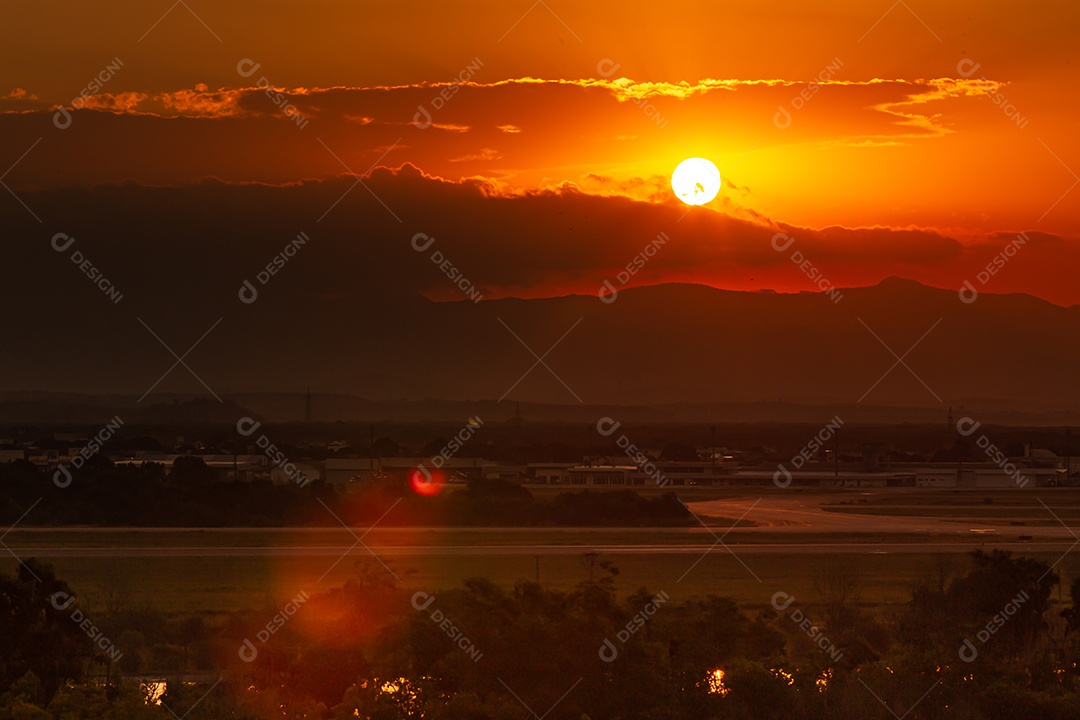 Lindo pôr do sol, com o aeroporto de Vitória em primeiro plano e uma nuvem em forma de vulcão ao fundo.