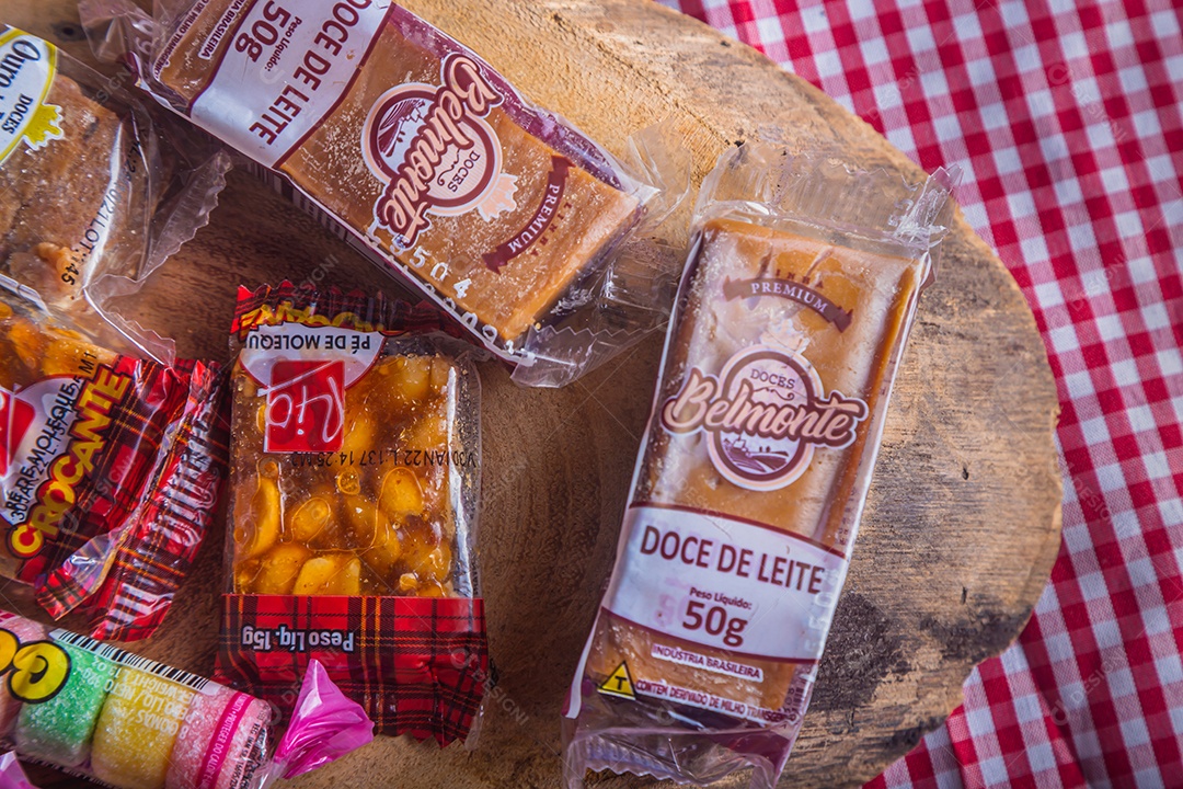 Festa junina, festa típica brasileira, vários doces na mesa com toalha xadrez vermelha.